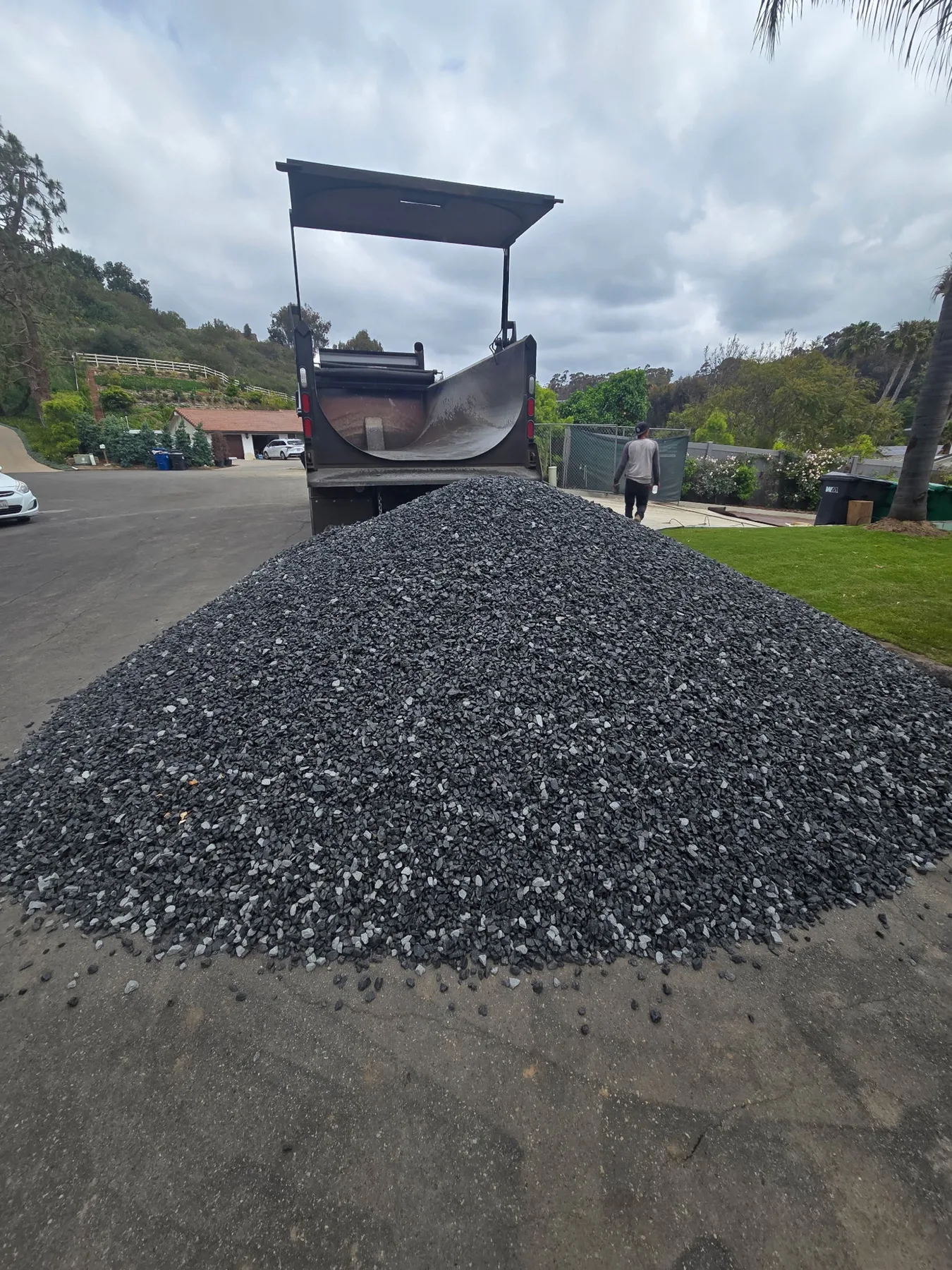 Large gravel pile delivered behind a dump truck